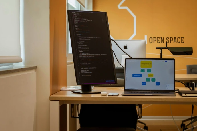 a laptop computer sitting on top of a wooden desk